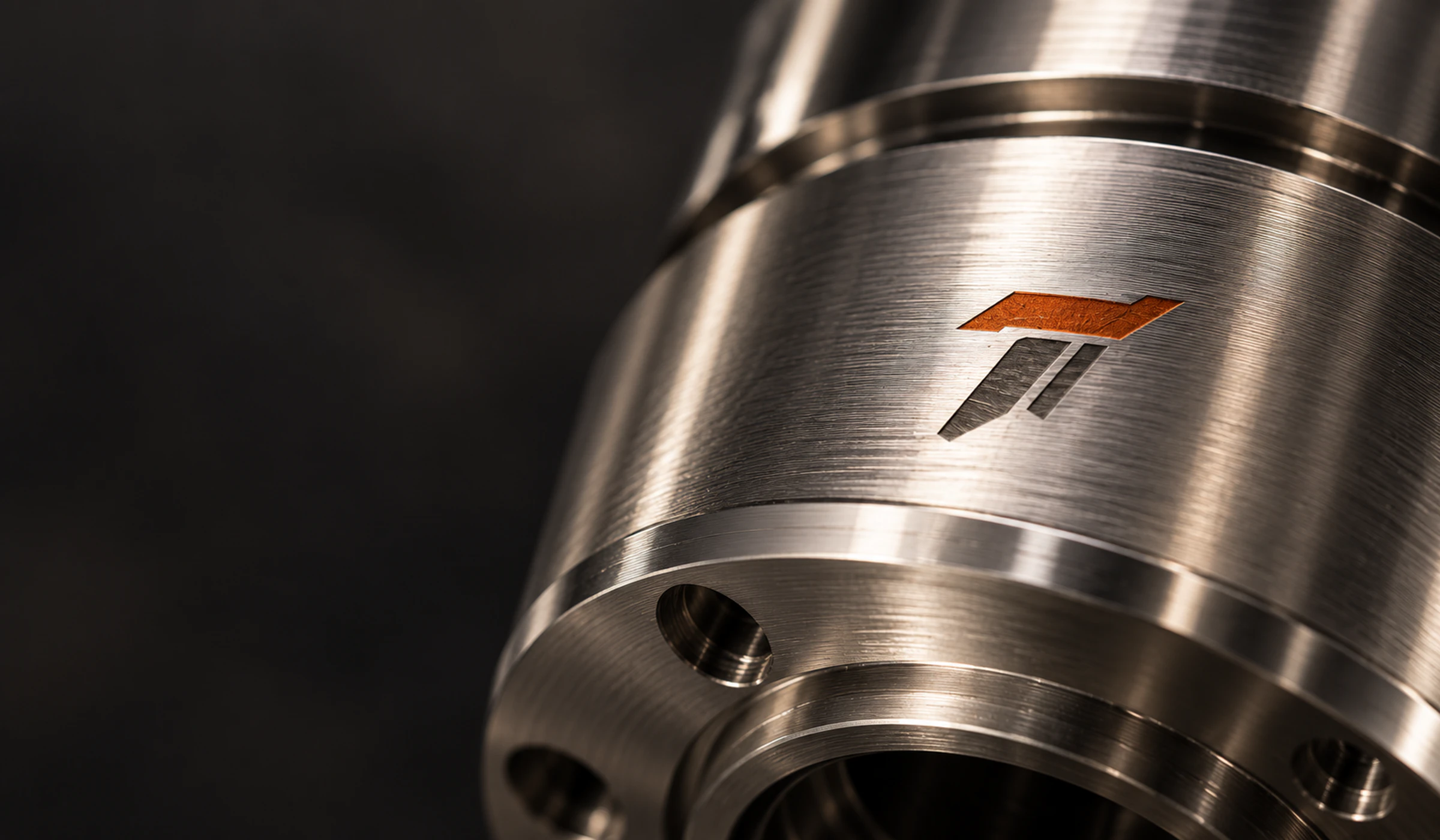 Precision-turned stainless steel component engraved with the Tenaxis mark